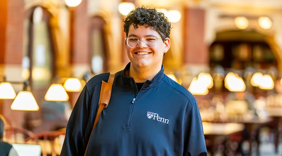 Noah Milad smiling inside Fisher Fine Arts Library