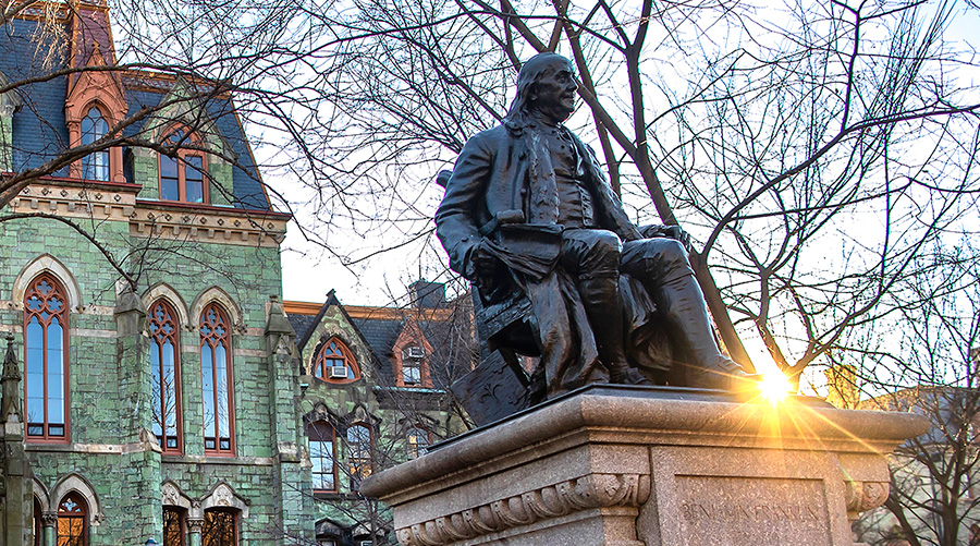 The statue of Benjamin Franklin on College Green at the University of Pennsylvania with College Hall in the background