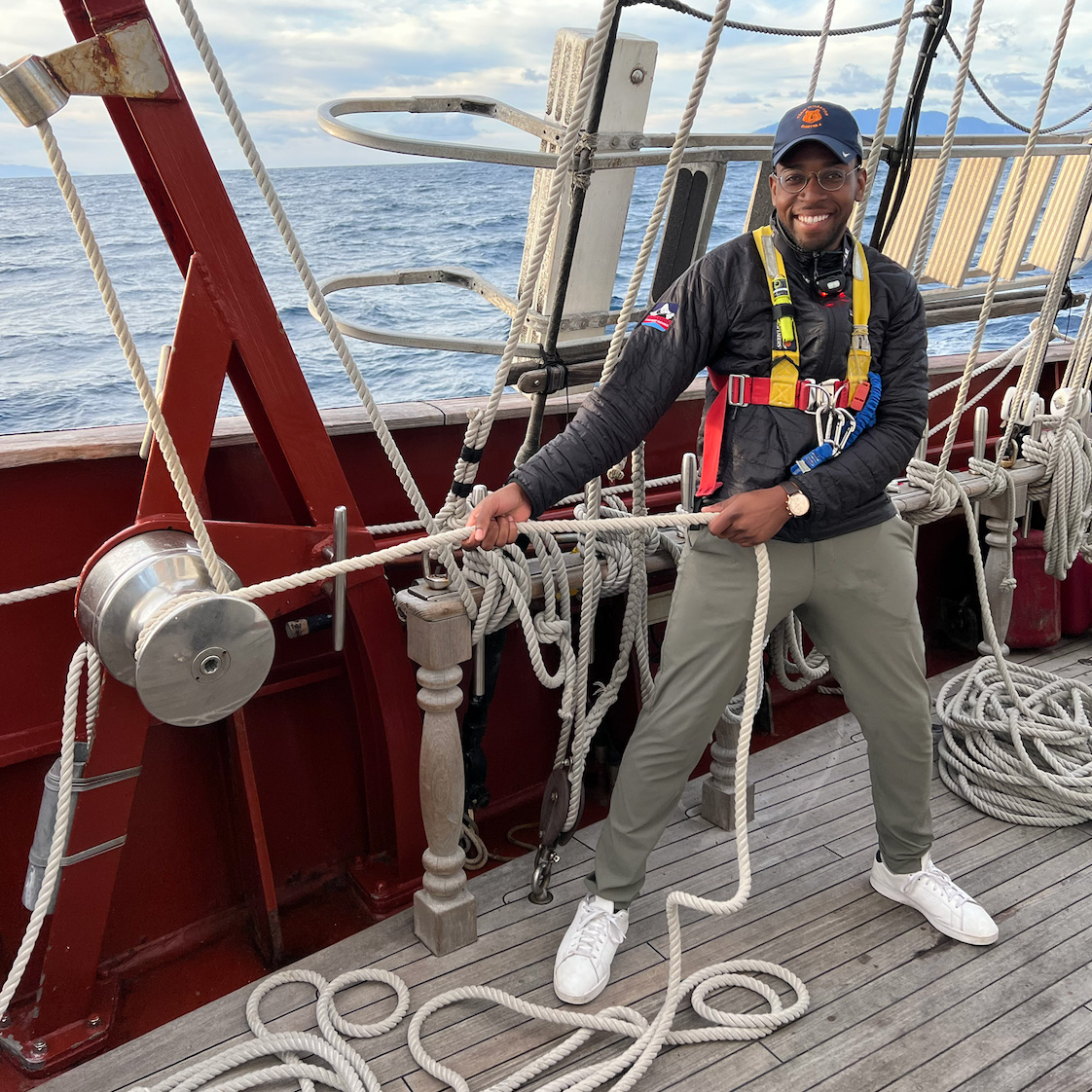Romel Singleton, WG’24, secures the rigging on a ship while smiling for the camera