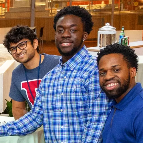 Group of young alumni smiling and enjoying each other's company.